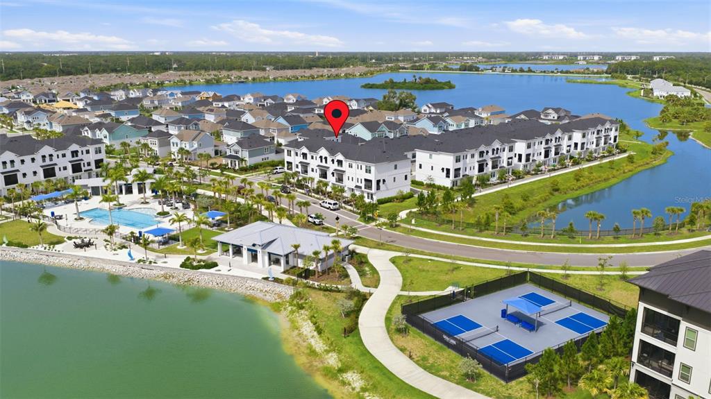An aerial view shows a residential community with townhomes, a swimming pool, and pickleball courts — 1528 SKYSAIL LANE, SARASOTA, FL