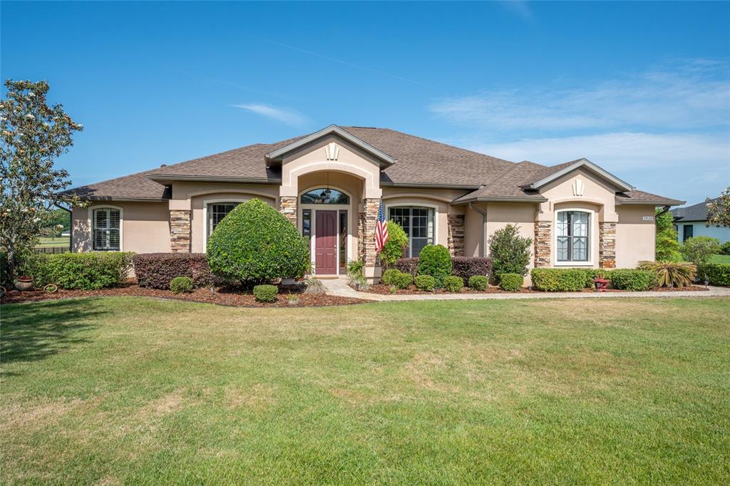 An aerial view of a single-story house with a driveway, pool enclosure, and large yard — 7830 SE 25TH AVENUE, OCALA, FL