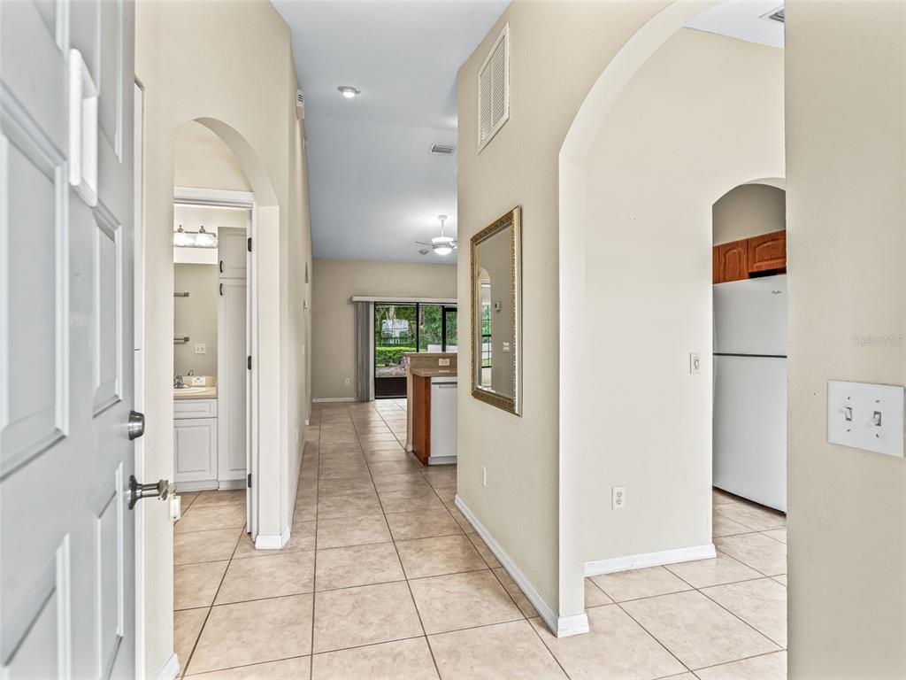 A tiled entryway leads to a living area with a kitchen visible on the right — 1701 SE 24TH ROAD UNIT 1702, OCALA, FL