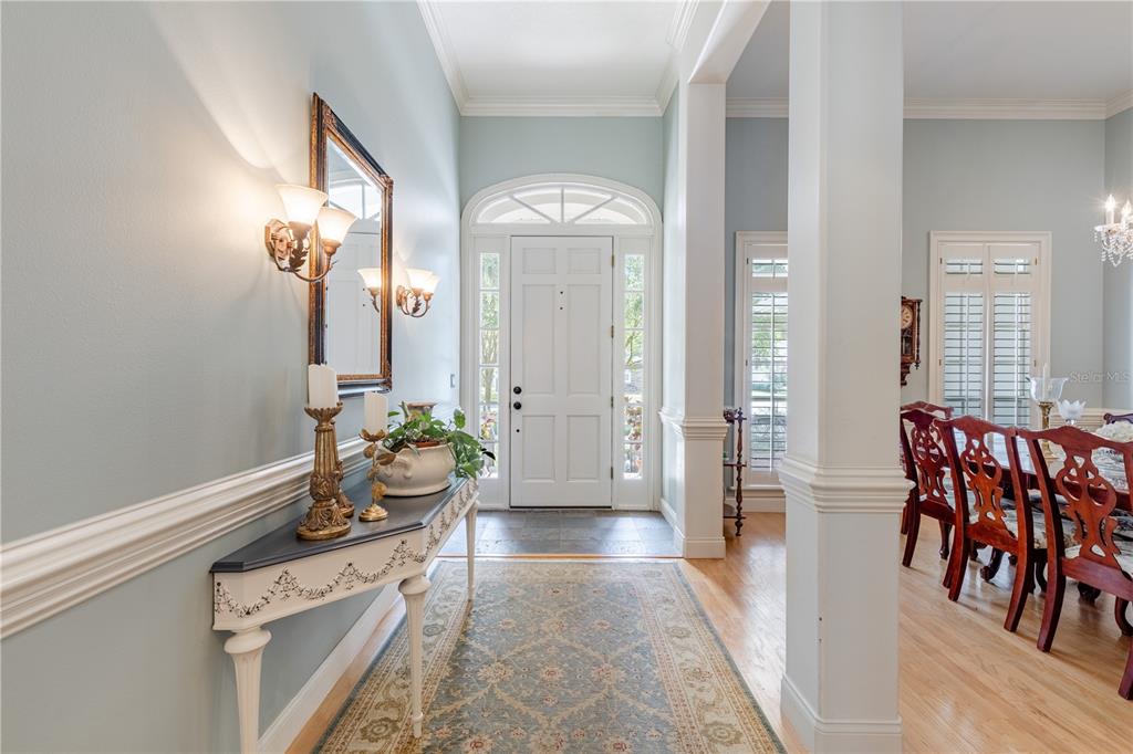 A screened-in swimming pool and spa with a brick border overlooking a pond — 34317 WINDLEY CIRCLE, EUSTIS, FL