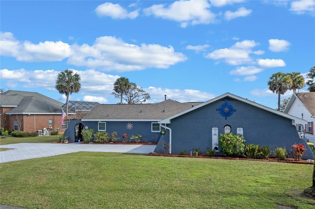 A blue single-story house with a compass rose decoration on the exterior wall — 1102 N PALMETTO STREET, LEESBURG, FL