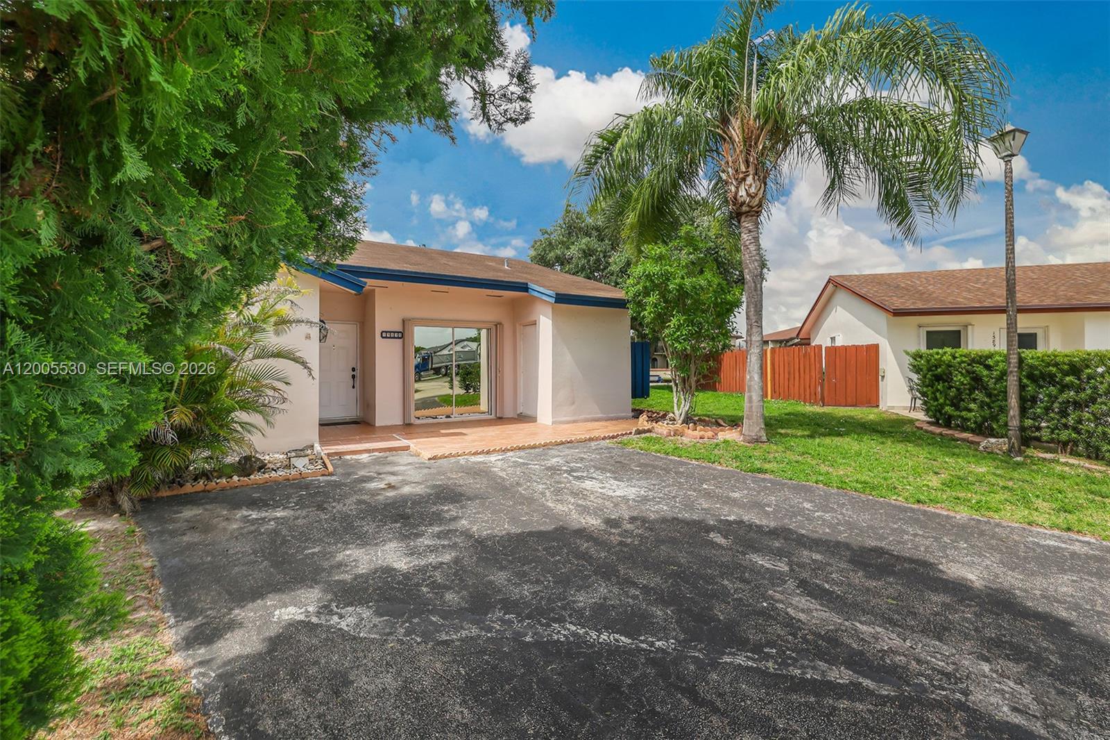 A single-story house with a paved driveway, a palm tree, and a small front patio — 13890 SW 43rd Ter, Miami FL 33175, MIAMI, FL