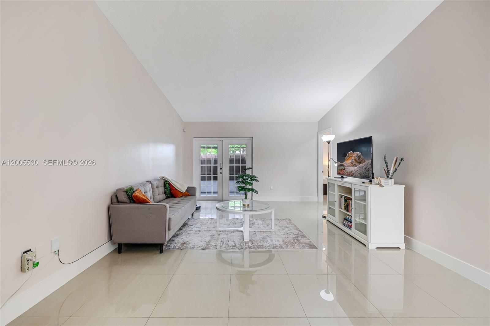 A living room features light tile flooring, a gray sofa, and a white media console — 13890 SW 43rd Ter, Miami FL 33175, MIAMI, FL