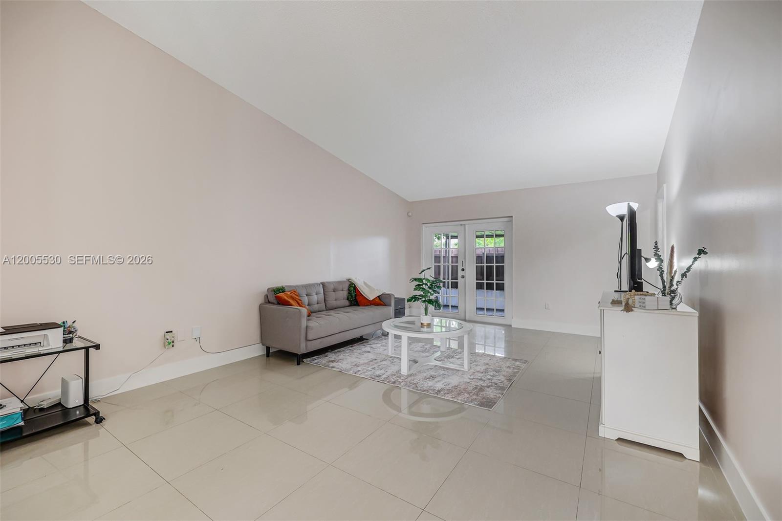 A living room features light tile floors, a gray sofa, and glass French doors — 13890 SW 43rd Ter, Miami FL 33175, MIAMI, FL