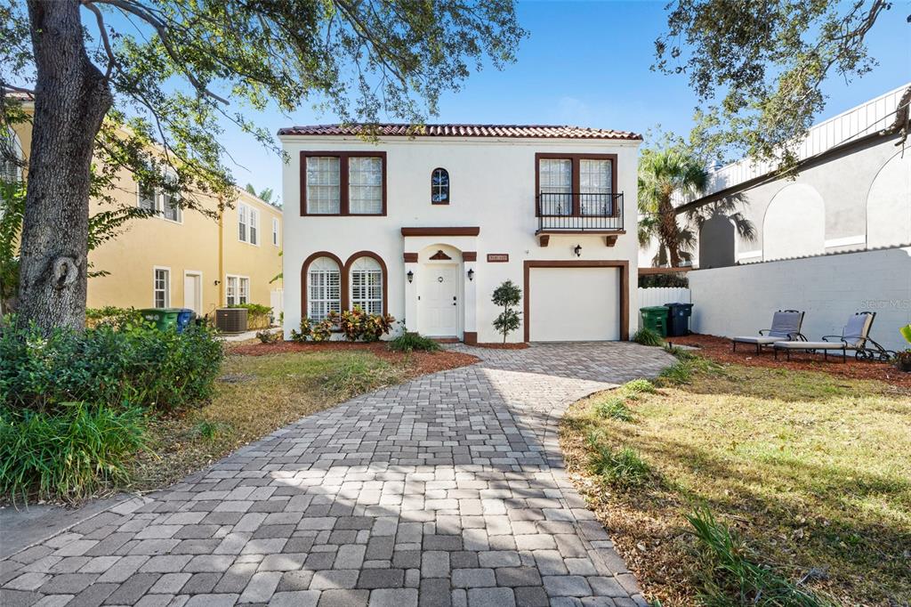 A two-story stucco house with a paver driveway, a garage, and a small balcony — 3710 W LEONA STREET, TAMPA, FL