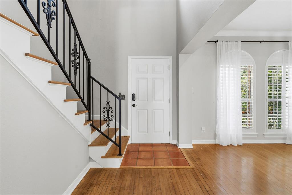 An entryway features a staircase with black iron railings, a white door, and tiled flooring — 3710 W LEONA STREET, TAMPA, FL