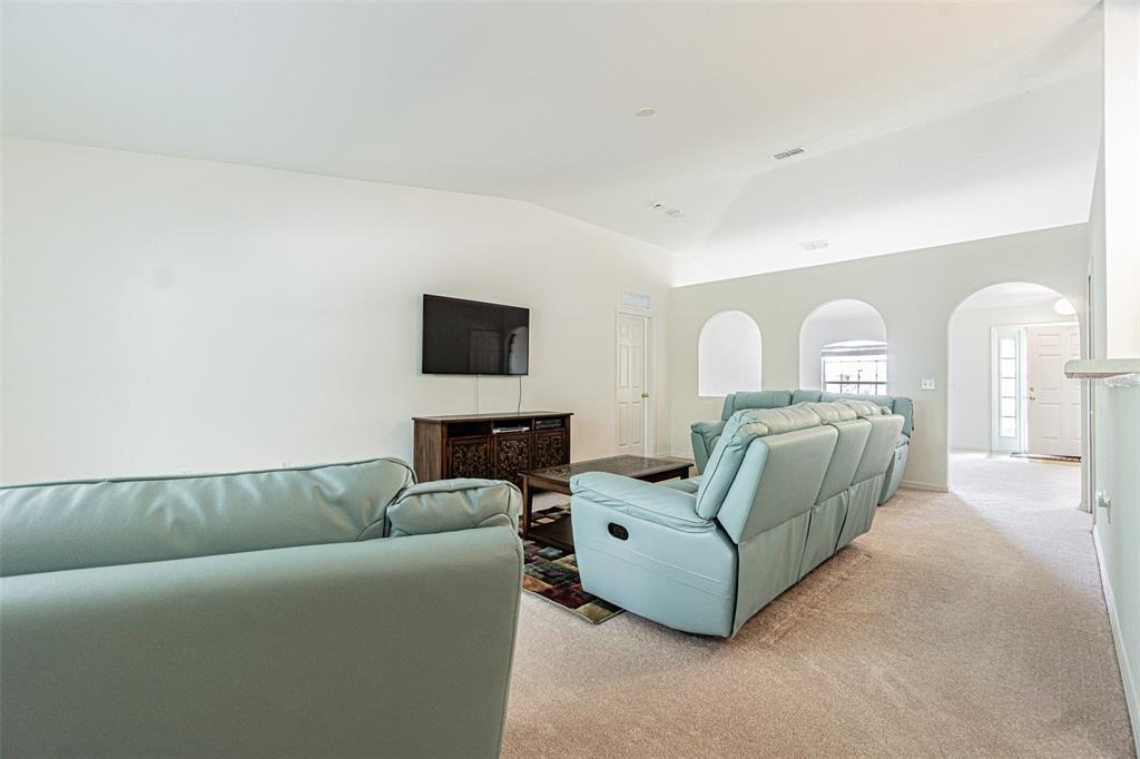 A living room features light blue reclining sofas, a television, and arched wall openings — 6283 LORRAINE LANE, SPRING HILL, FL