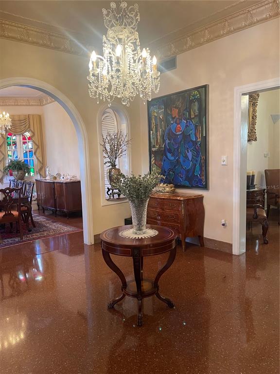 A foyer with a crystal chandelier, a round pedestal table, and a large abstract painting — 1404 VILA MAYO, SAN JUAN, PR