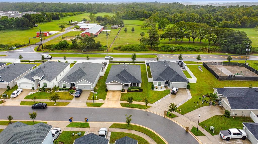 An aerial view shows a suburban street with several single-family homes and a large field — 190 POLERMO AVENUE, ST CLOUD, FL