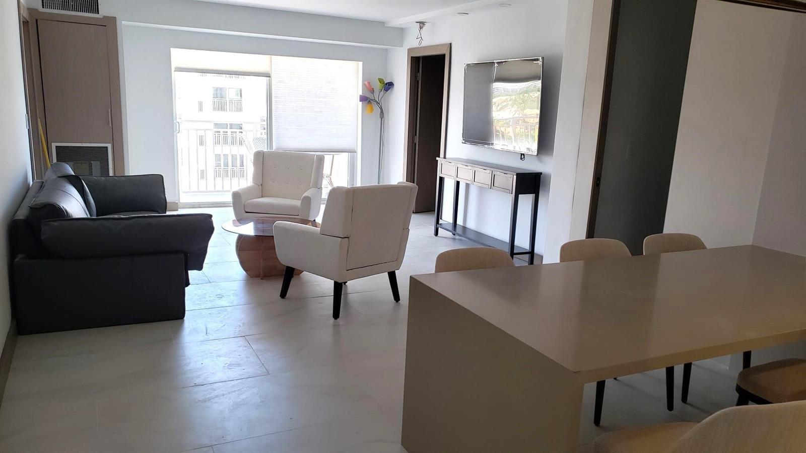 A living and dining area features a dark sofa, two white armchairs, and tile flooring — 4511 S Ocean Boulevard # 904, Highland Beach FL 33487, HIGHLAND BEACH, FL