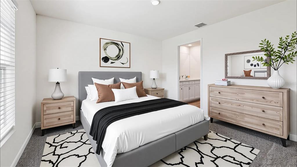 A bedroom features a gray upholstered bed, light wood furniture, and a patterned area rug — 9715 N MITCHELLE DRIVE, DUNNELLON, FL