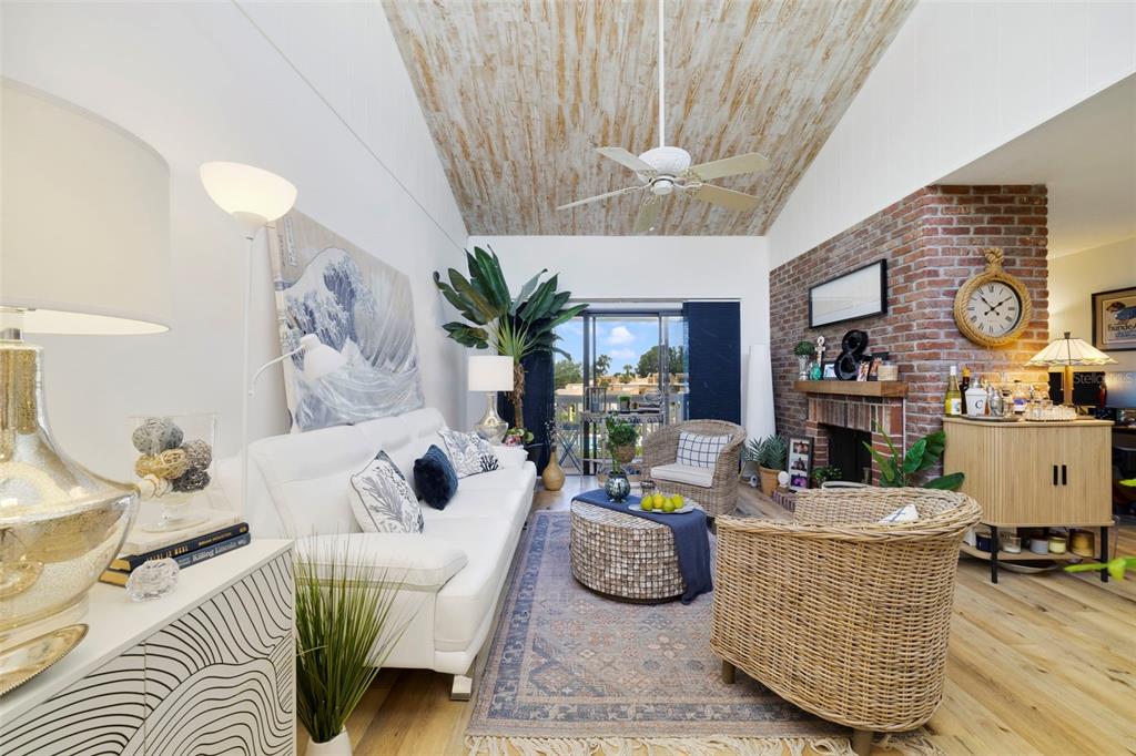 A living room features a vaulted wood-paneled ceiling, a brick fireplace, and a white sofa — 1051 S HIGHLAND STREET UNIT 7D, MOUNT DORA, FL