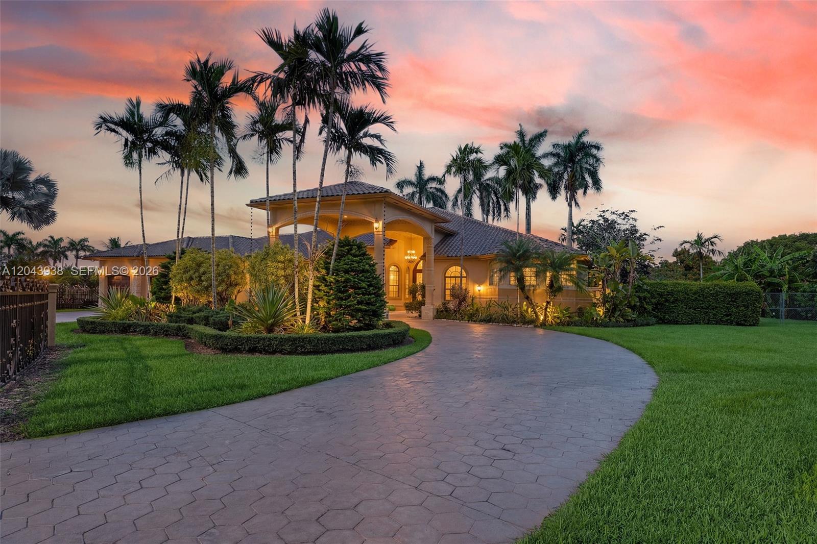 A large house with a paved driveway and palm trees under a sunset sky — 29482 SW 193rd Ct, Homestead FL 33030, HOMESTEAD, FL