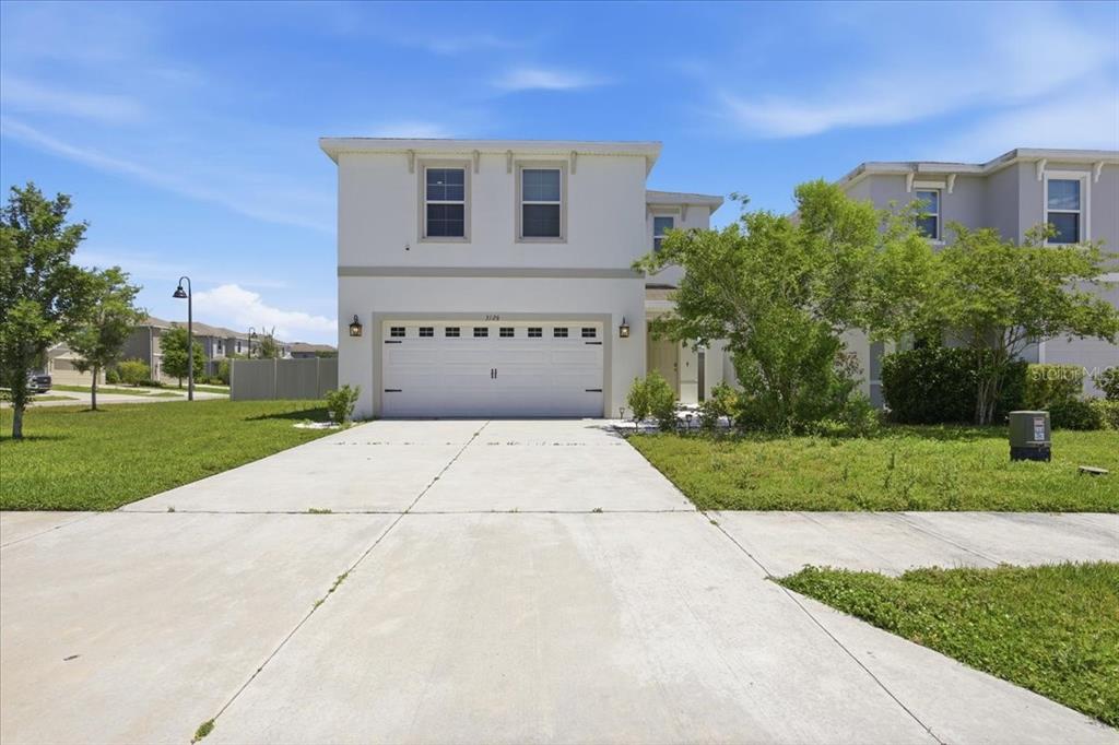 A two-story house with a white stucco exterior and a two-car garage — 3126 SUNCOAST BLEND DRIVE, ODESSA, FL