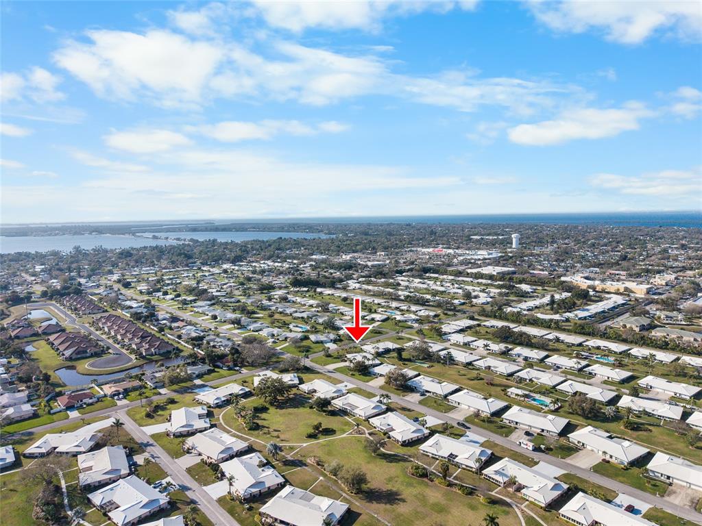 An aerial view shows a residential neighborhood with a red arrow pointing to a house — 6712 11TH AVENUE W UNIT 5601, BRADENTON, FL