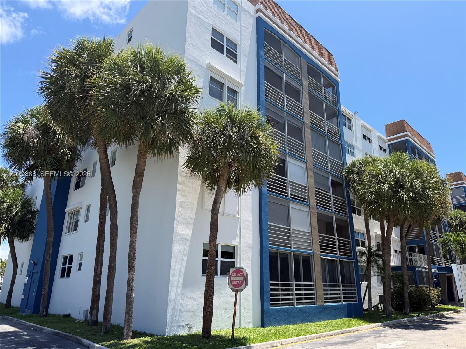 A multi-story white and blue apartment building stands behind several palm trees — 501 E Dania Beach Blvd # 4D, Dania Beach FL 33004, DANIA BEACH, FL