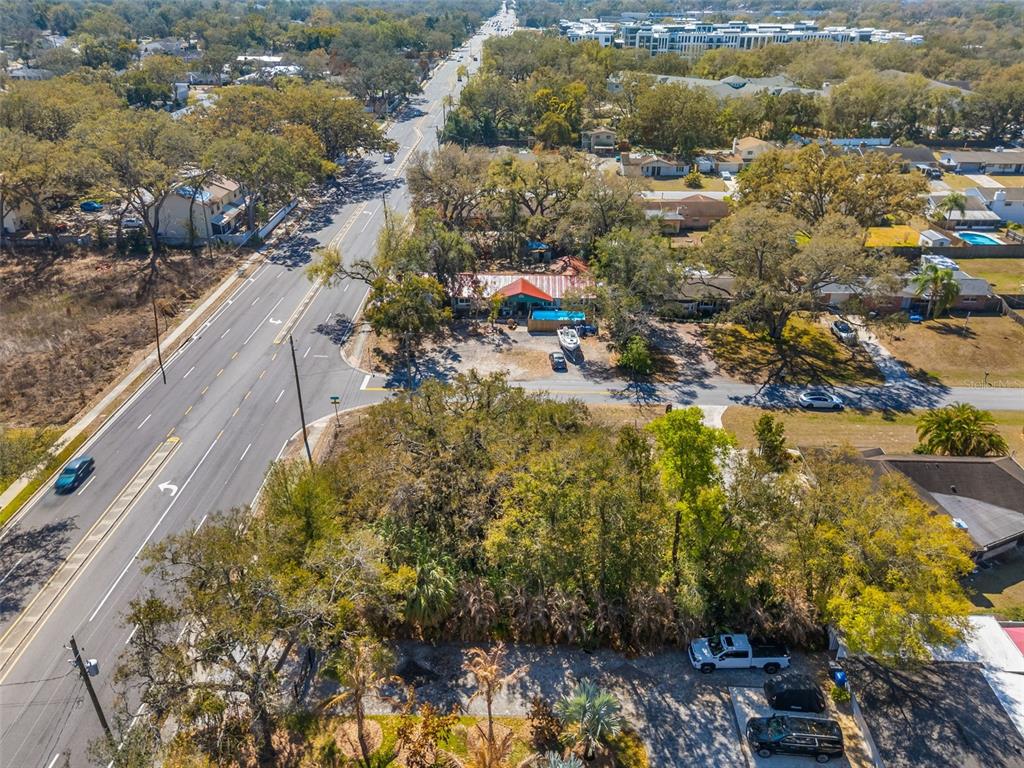 An aerial view shows a wooded lot, a house with a pool, and a nearby road — 702 WESTWOOD DRIVE, BRANDON, FL