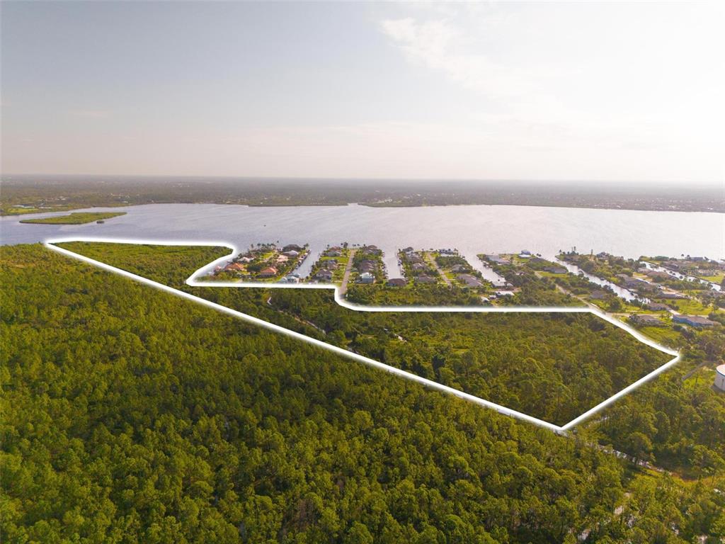An aerial view shows a large, undeveloped plot of land outlined in white near water — 2925 VANCE TERRACE, PORT CHARLOTTE, FL