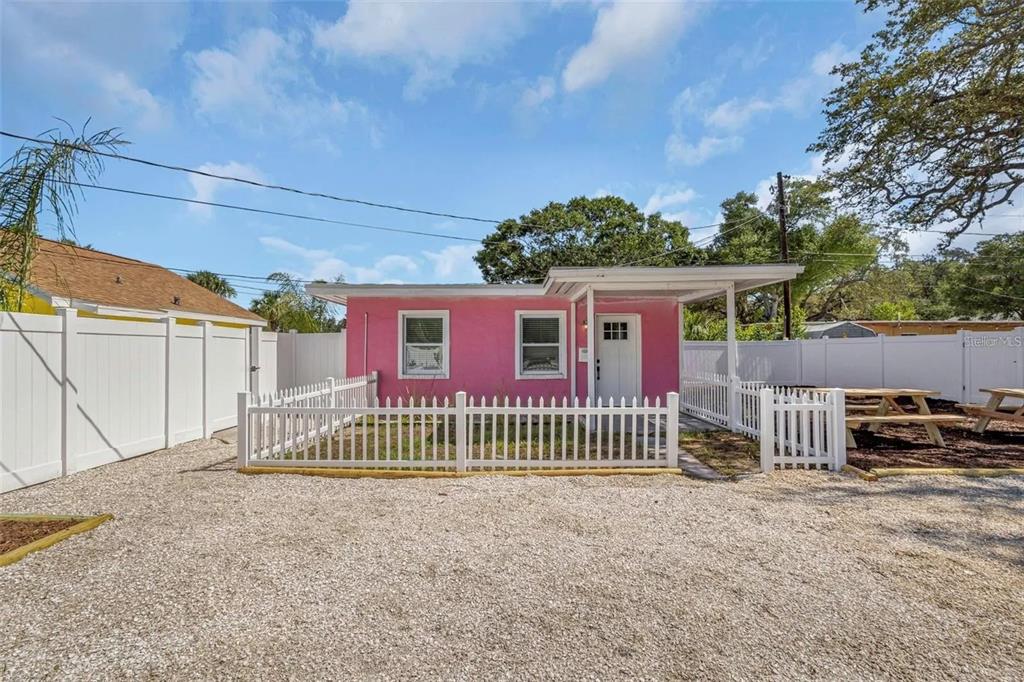 A small, bright pink house with a white picket fence and a gravel driveway — 1500 CLEARWATER LARGO ROAD N, LARGO, FL