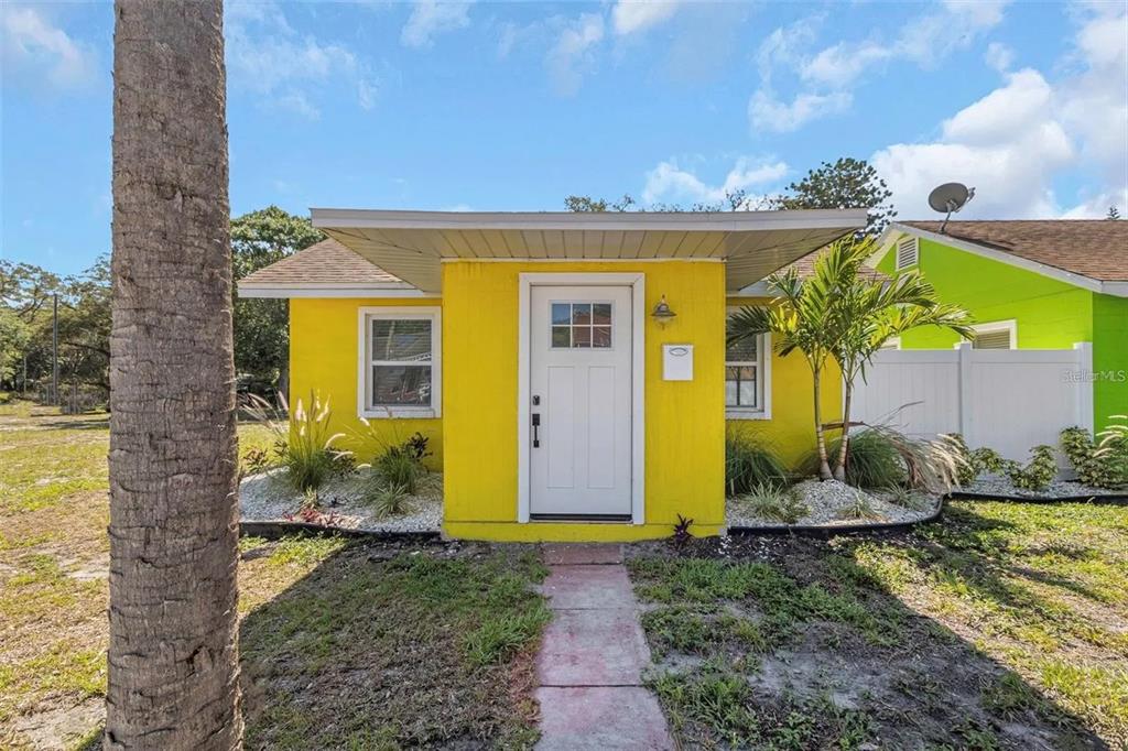 A bright yellow house features a white front door and a small covered entryway — 1500 CLEARWATER LARGO ROAD N, LARGO, FL
