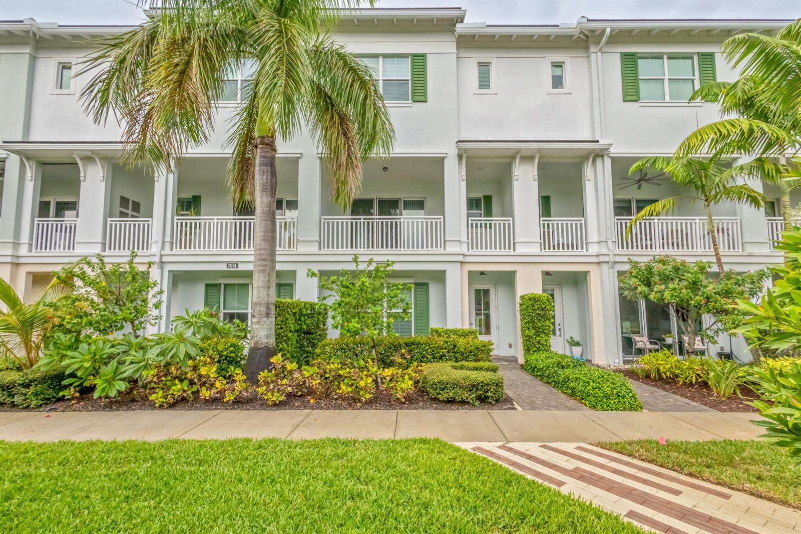 A three-story townhouse exterior features white balconies, green shutters, and a palm tree out front — 7089 Edison Place, Palm Beach Gardens FL 33418, PALM BEACH GARDENS, FL