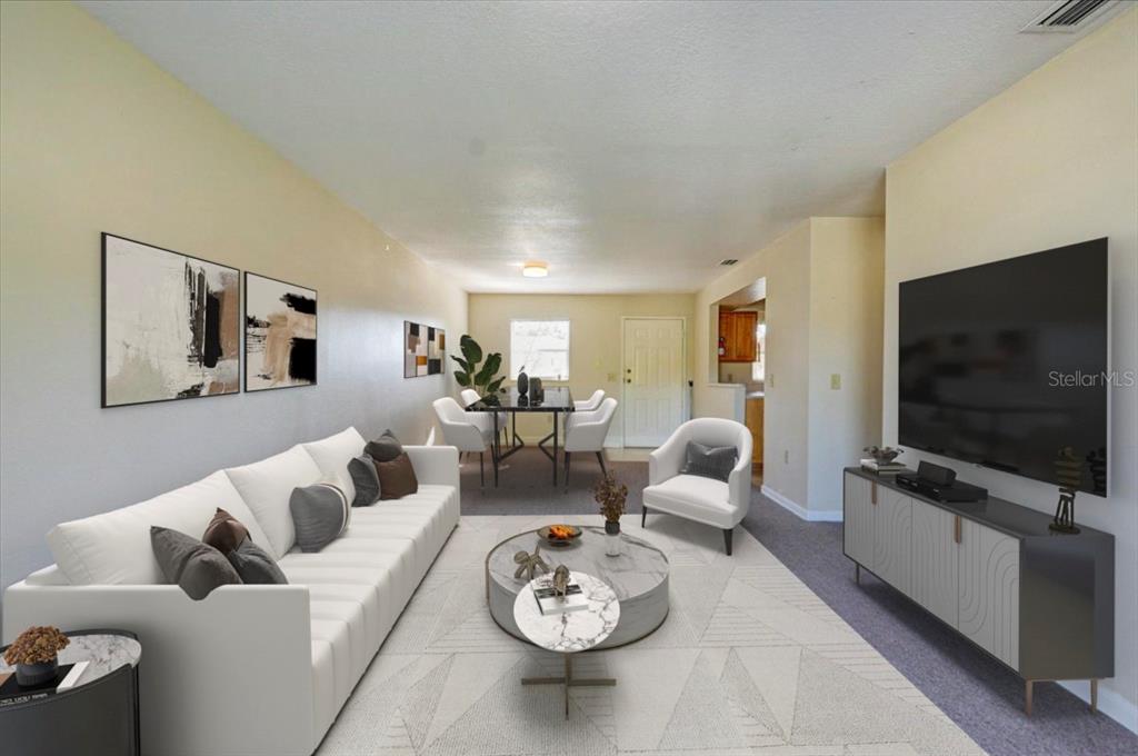 A living room with a white sofa, round coffee table, and television on a console — 1213 UNITAH AVENUE UNIT 2, LAKELAND, FL