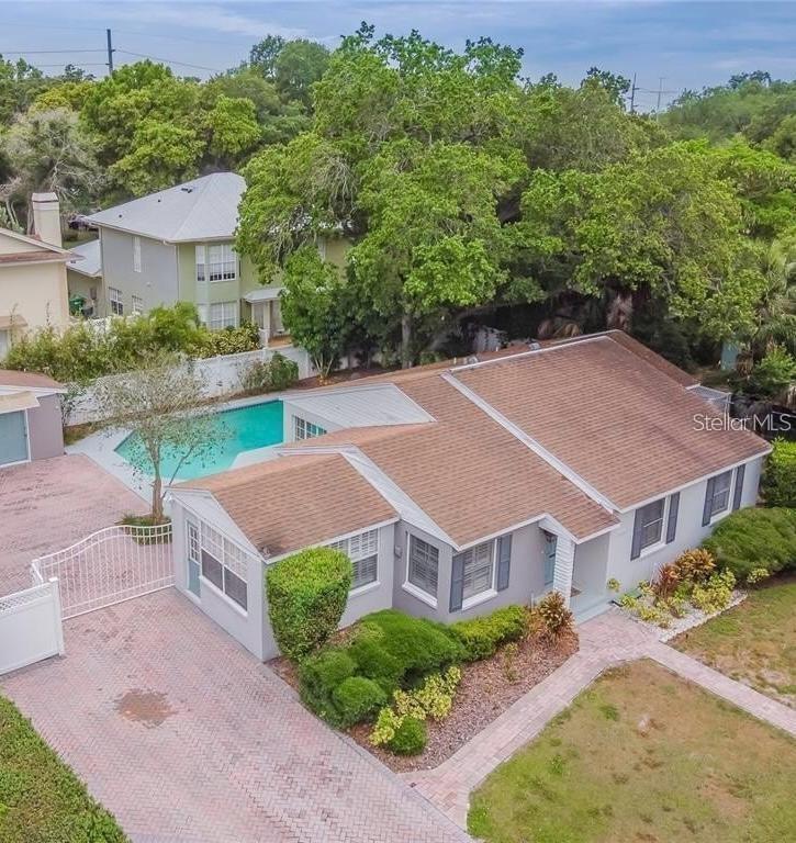 An aerial view of a single-story house with a swimming pool and paved driveway — 4014 W PALMIRA AVENUE, TAMPA, FL