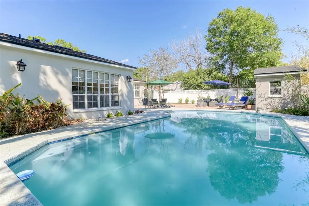 A swimming pool sits in the backyard of a house with a small detached shed — 4014 W PALMIRA AVENUE, TAMPA, FL