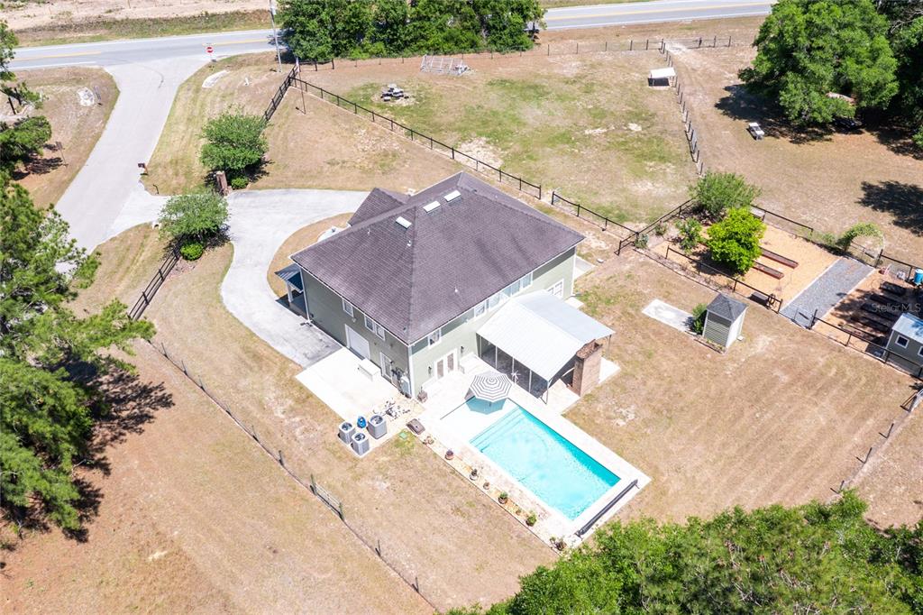 An aerial view shows a house with a pool, patio, and fenced yard — 101 RAMSEY DRIVE, MELROSE, FL
