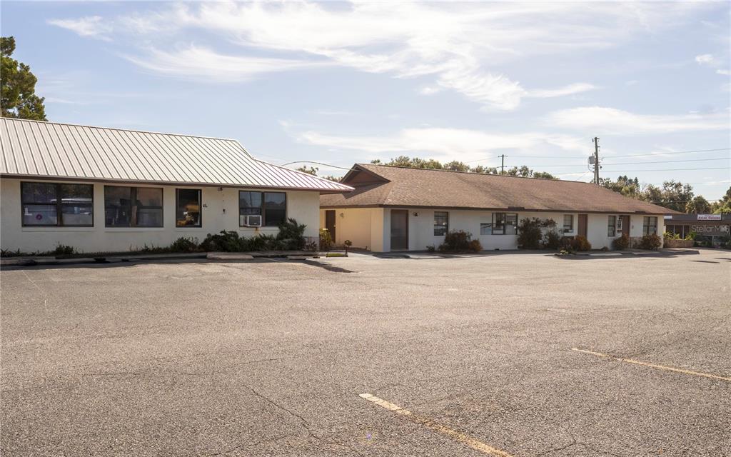 Two single-story commercial buildings with parking lots in front under a blue sky — 915 E ALFRED STREET, TAVARES, FL