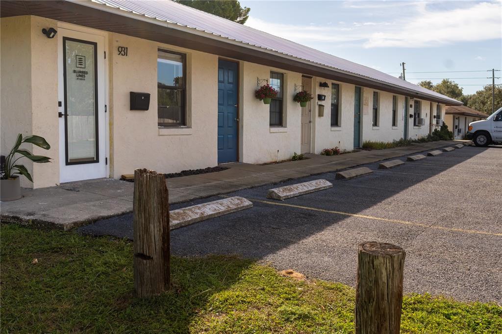 A single-story commercial building with multiple exterior doors and a paved parking lot in front — 915 E ALFRED STREET, TAVARES, FL