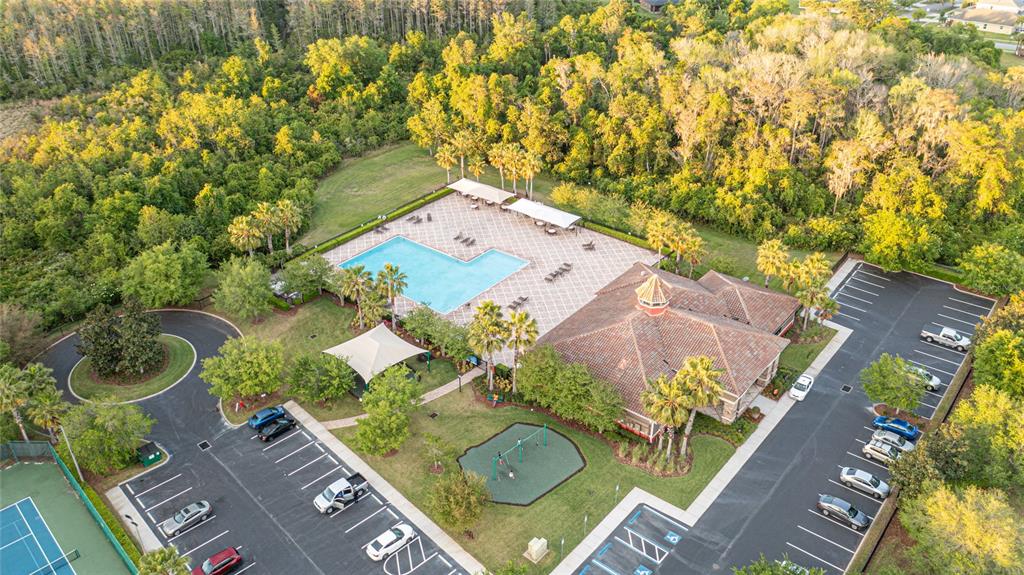 An aerial view of a community clubhouse featuring a swimming pool, playground, and parking lots — 14921 BRAYWOOD TRAIL, ORLANDO, FL