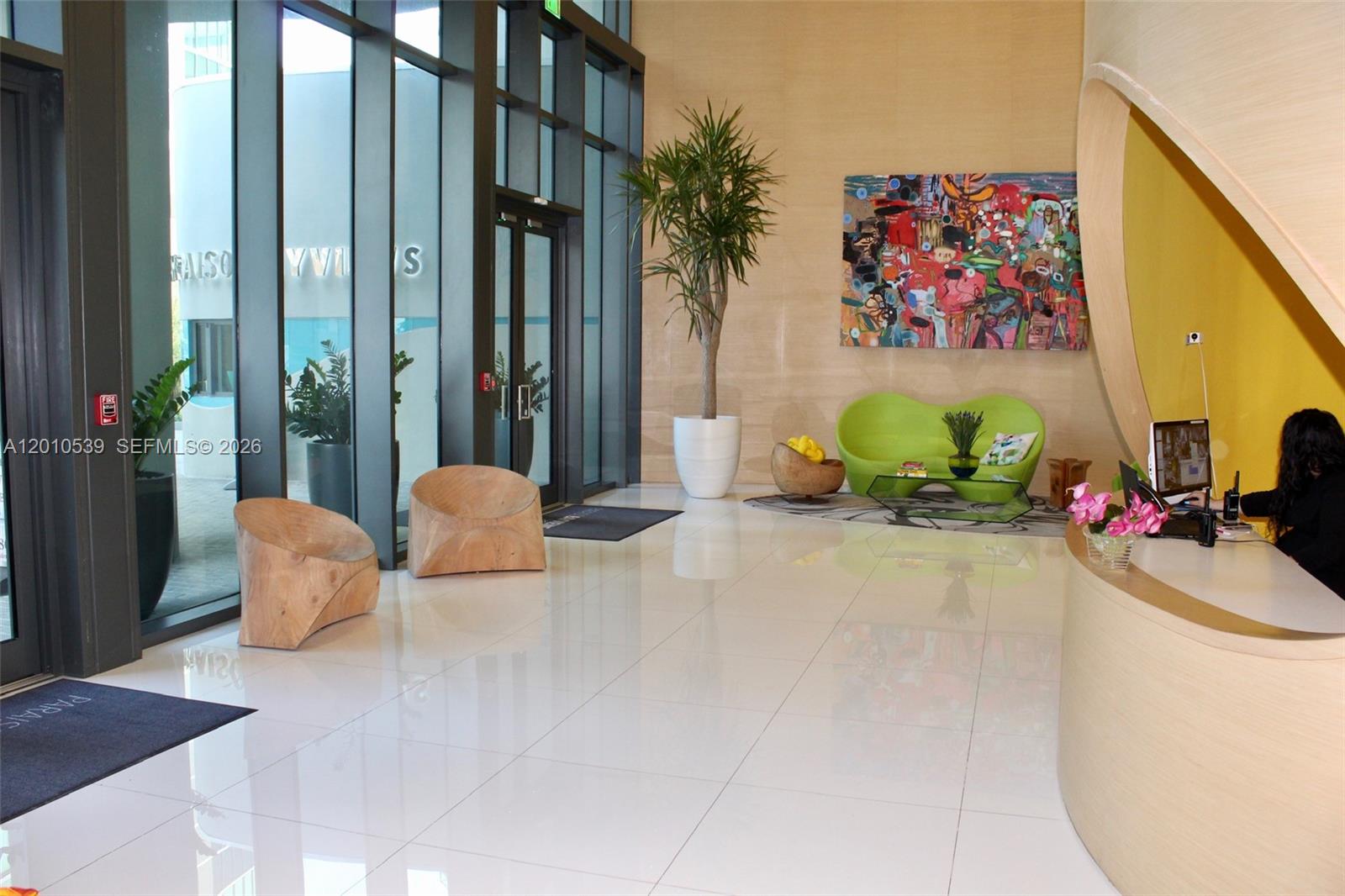A modern lobby features a reception desk, seating area, large windows, and abstract wall art — 501 NE 31st St # 2705, Miami FL 33137, MIAMI, FL