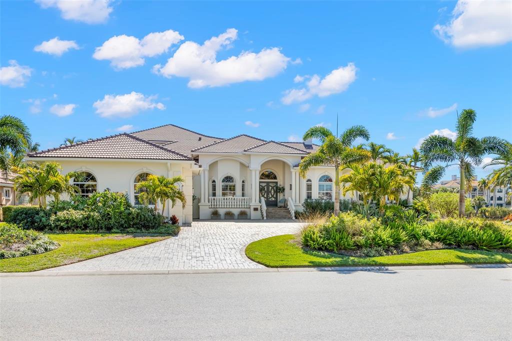 A single-story stucco house with a tiled roof, arched windows, and a paved driveway — 5264 61ST AVENUE S, ST PETERSBURG, FL