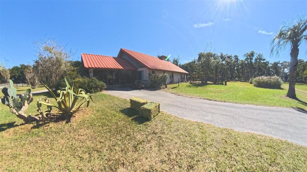 A single-story house with a red tile roof sits at the end of a driveway — 4540 W HIGHWAY 318, CITRA, FL