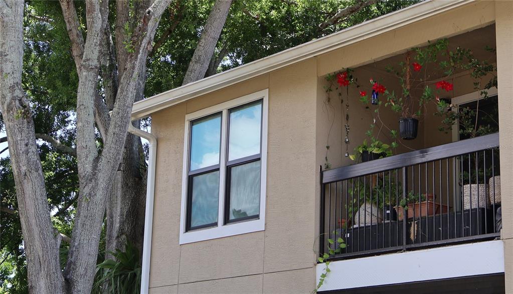 A tan building exterior features a window and a balcony with a black metal railing — 4001 CROCKERS LAKE BOULEVARD UNIT 21, SARASOTA, FL