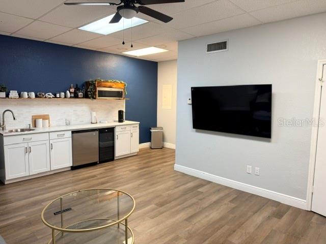 A room features a kitchenette with white cabinets, a dark blue accent wall, and a television — 223 N COMMONWEALTH AVENUE SW, POLK CITY, FL