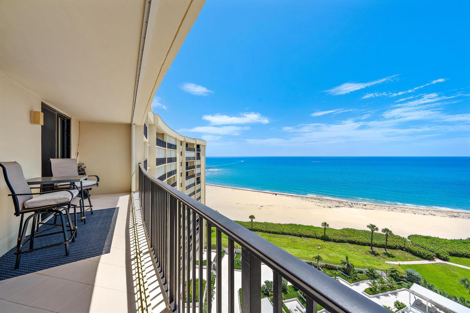 A balcony with outdoor furniture overlooks a sandy beach and the blue ocean — 200 Ocean Trail Way # 1205, Jupiter FL 33477, JUPITER, FL