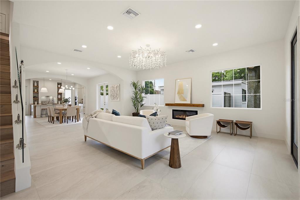 A bright living room with white tile floors, a modern chandelier, and an open kitchen — 2430 CHANTILLY AVENUE, WINTER PARK, FL