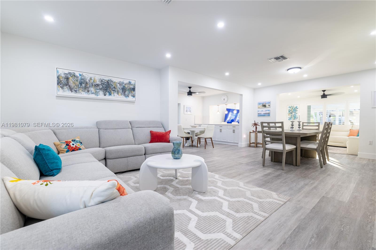 A living and dining area features light gray flooring, a sectional sofa, and white walls — 19600 Gulfstream Rd, Cutler Bay FL 33157, CUTLER BAY, FL