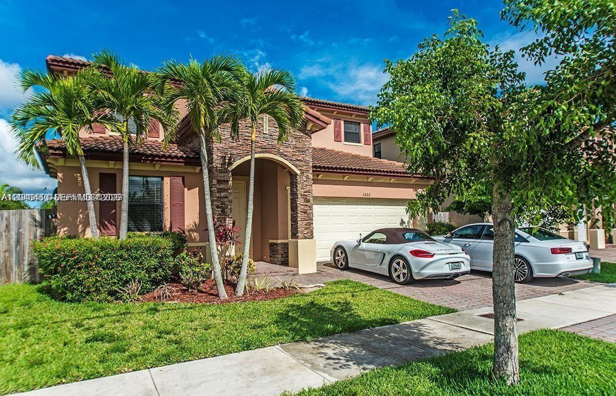 A two-story house with a stone facade, palm trees, and two cars in the driveway — 1522 SW 144th Ave, Miami FL 33184, MIAMI, FL