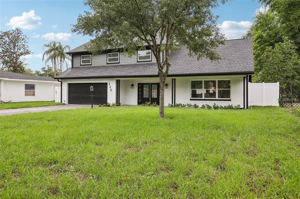 A two-story house with a white brick exterior, black trim, and a two-car garage — 226 WILLOWICK AVENUE, TEMPLE TERRACE, FL