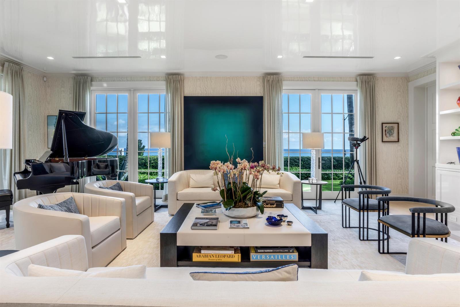 A bright living room features a grand piano, white seating, a large coffee table, and ocean views — 456 S Ocean Boulevard, Palm Beach FL 33480, PALM BEACH, FL