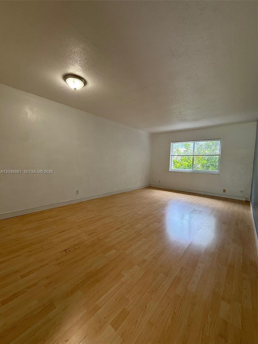 An empty room features light wood-look flooring, white walls, and a single window — 3300 NE 10th Ter # 53, Pompano Beach FL 33064, POMPANO BEACH, FL