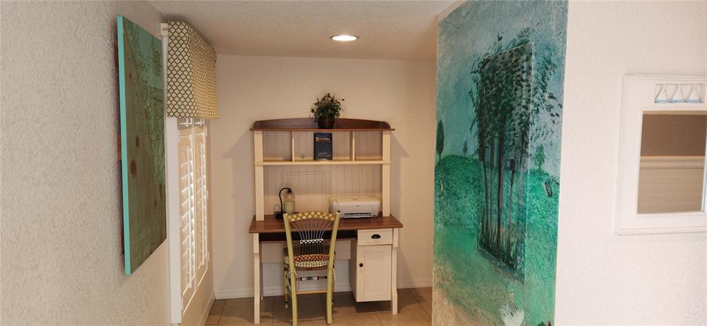 A small home office nook features a wooden desk with a hutch and a mural — 9600 FIDDLERS GREEN CIRCLE UNIT 110, ROTONDA WEST, FL
