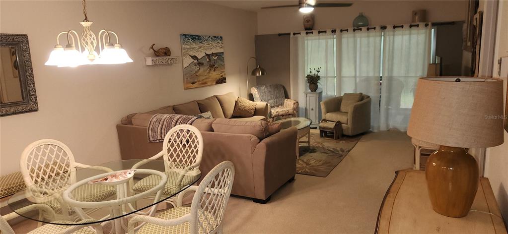 A dining area with a glass table and a living room with a sectional sofa — 9600 FIDDLERS GREEN CIRCLE UNIT 110, ROTONDA WEST, FL