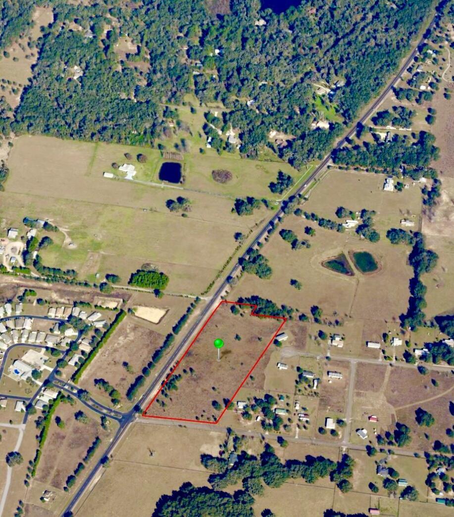 An aerial view shows a vacant, rectangular plot of land outlined in red near a road — 7451 E Derby Oaks Drive, FL 34436, FL