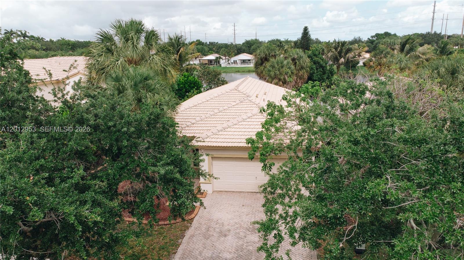 An aerial view shows a single-story house with a tiled roof and a paved driveway — 4595 SW 125th Ln, Miramar FL 33027, MIRAMAR, FL
