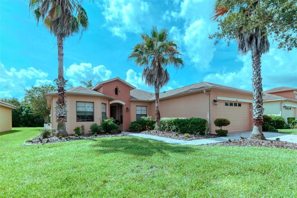A single-story peach-colored house with a two-car garage and three palm trees in the yard — 280 INDIAN WELLS AVENUE, KISSIMMEE, FL
