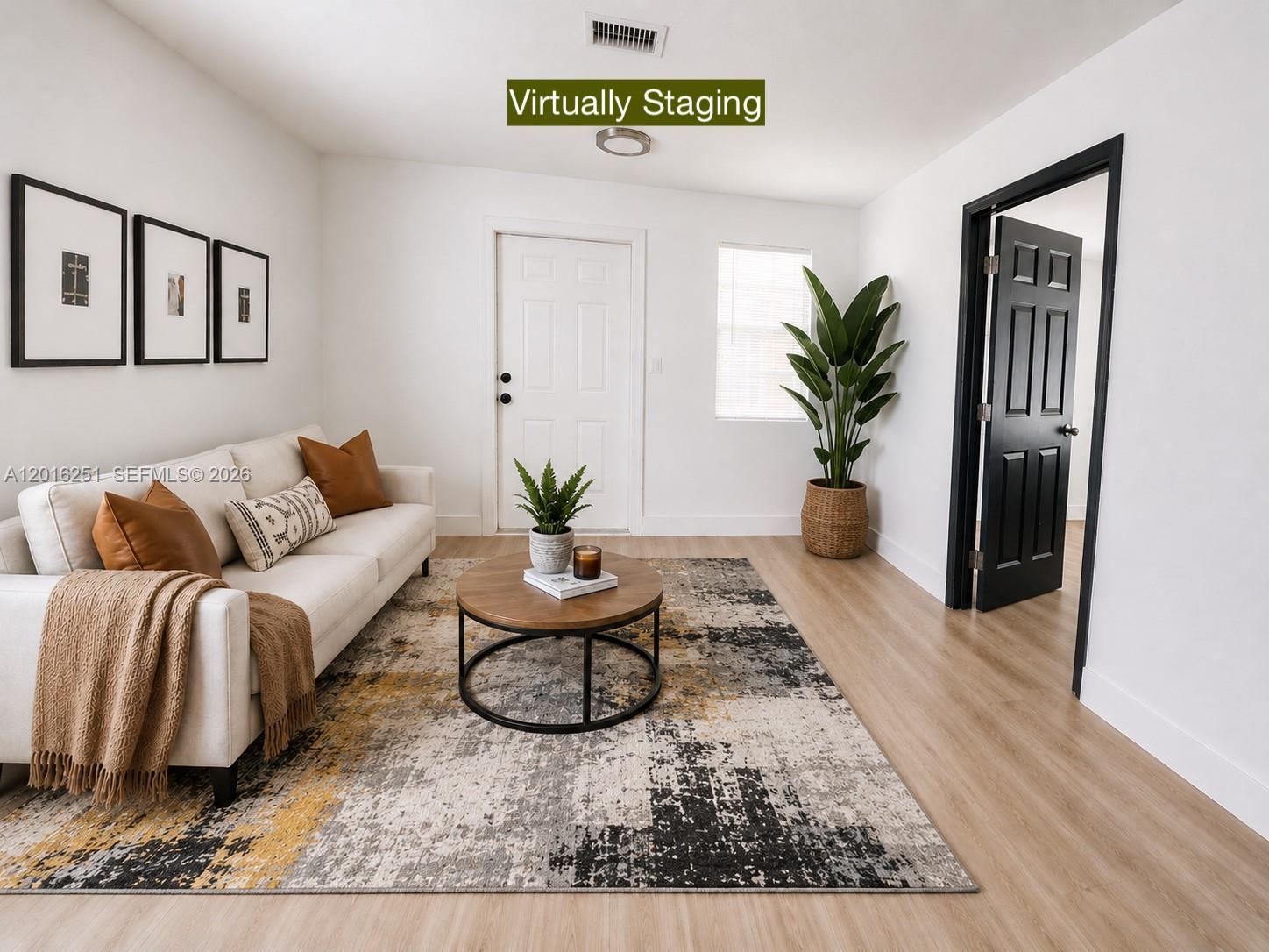 A living room features a sofa, round coffee table, area rug, and a black door — 1669 NW 70th St, Miami FL 33147, MIAMI, FL